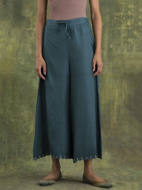 w teal solid flared pants with scalloped hem and embroidery detail partially elasticated waistband.